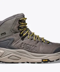 נעל הרים Hoka Kaha 3 GTX בגוון אפור-חצץ עם שרוכים ירוקים וסוליית Vibram