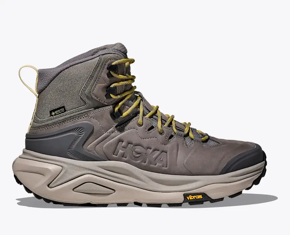 נעל הרים Hoka Kaha 3 GTX בגוון אפור-חצץ עם שרוכים ירוקים וסוליית Vibram